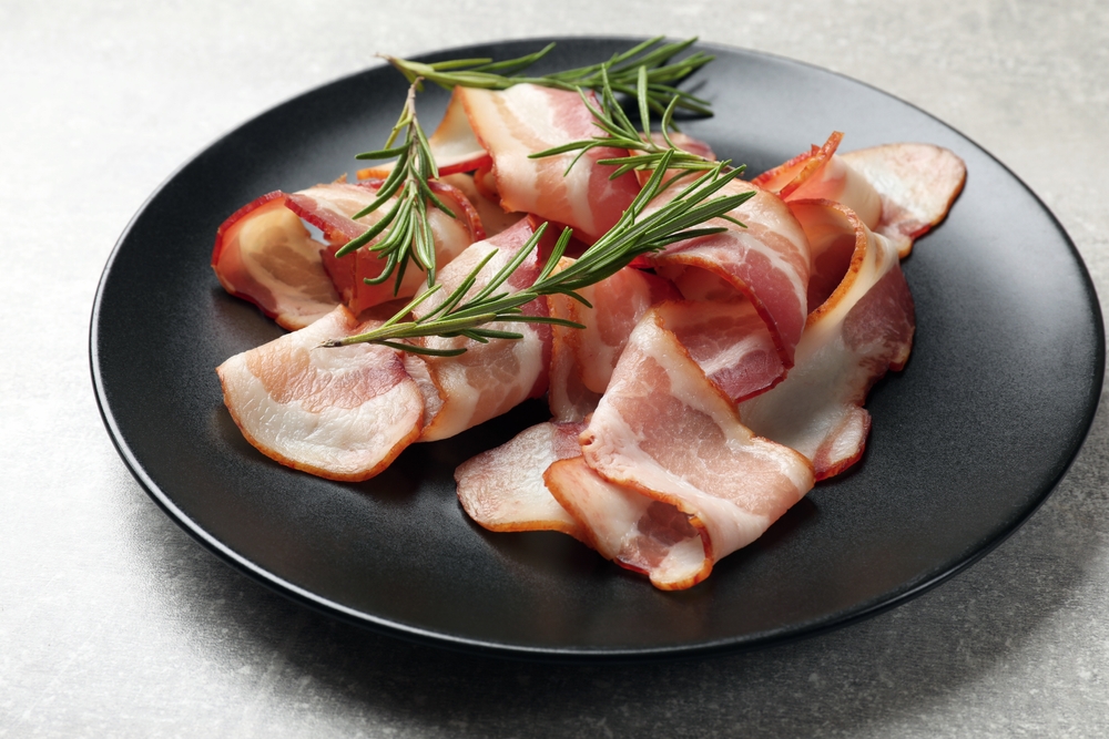 Bacon on plate served with rosemary